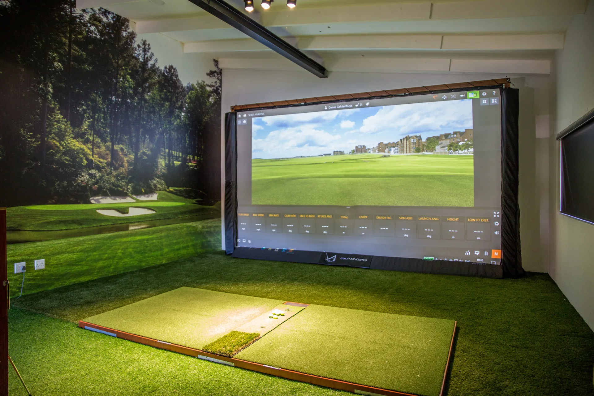 The Golf Concepts fitting bay: hitting mat, TrackMan simulator screen showing St Andrews, and the thirteen measured parameters across the bottom of the display