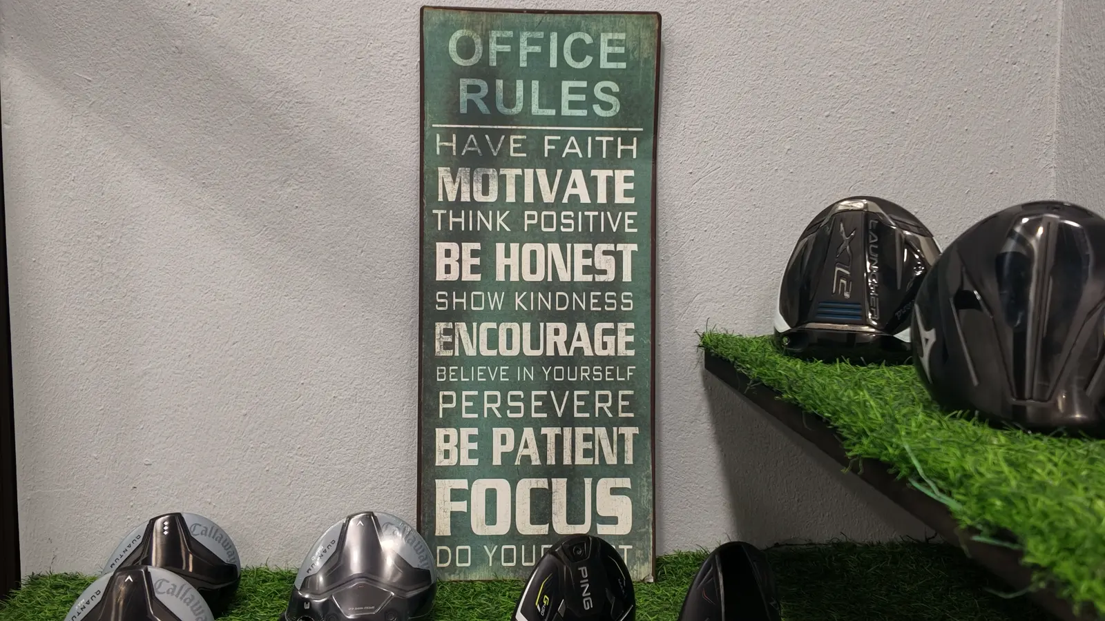 The Office Rules board on the wall at Golf Concepts, beside a shelf of driver heads